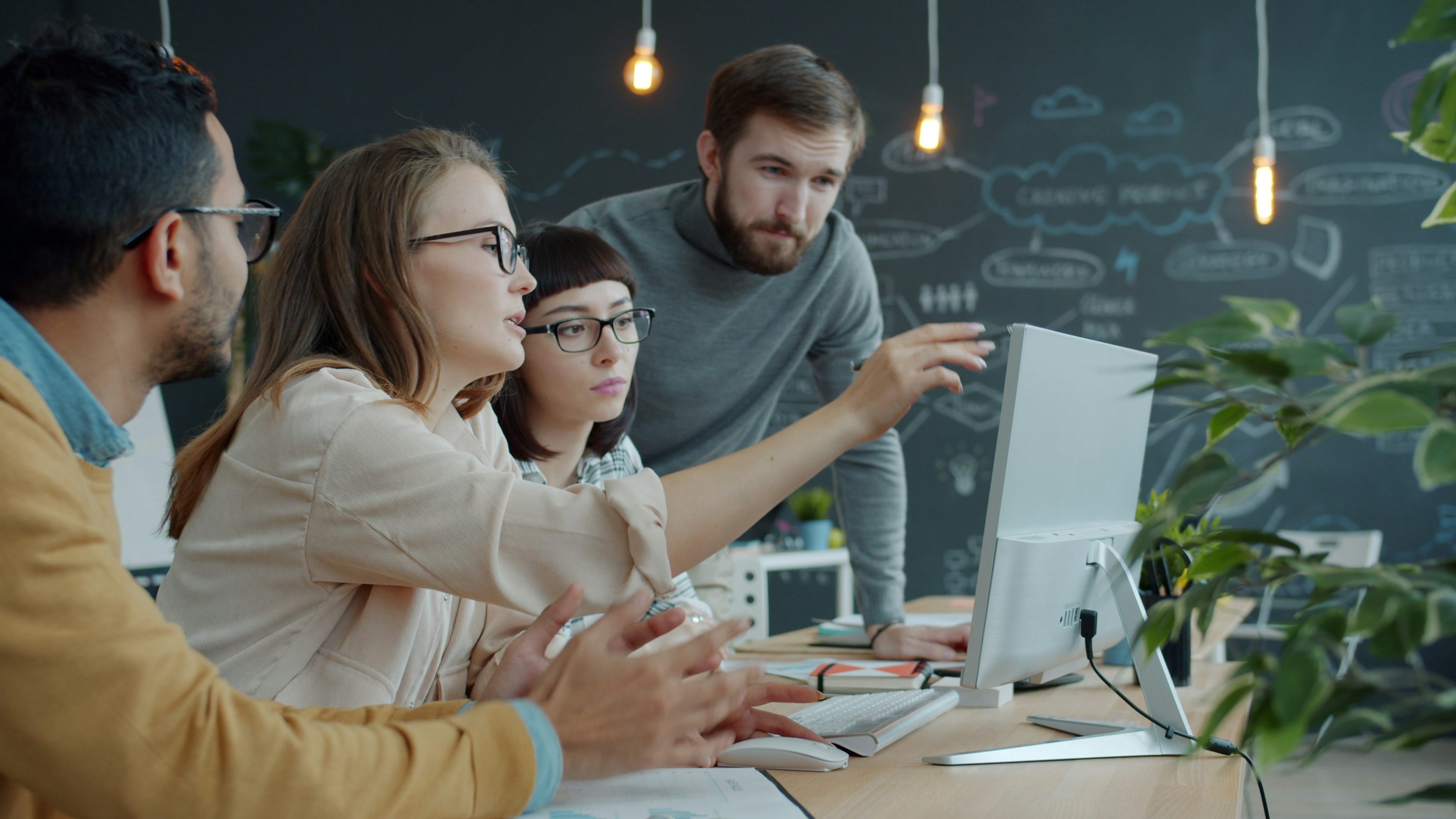 Team collaborating around a computer in an office.